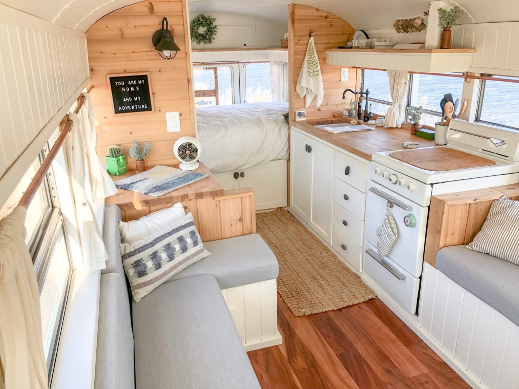 Beautiful and airy skoolie interior, parked near water. 