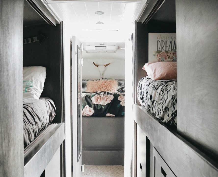 Trebventure's chic skoolie interior with two bunkbeds and a master bedroom. 