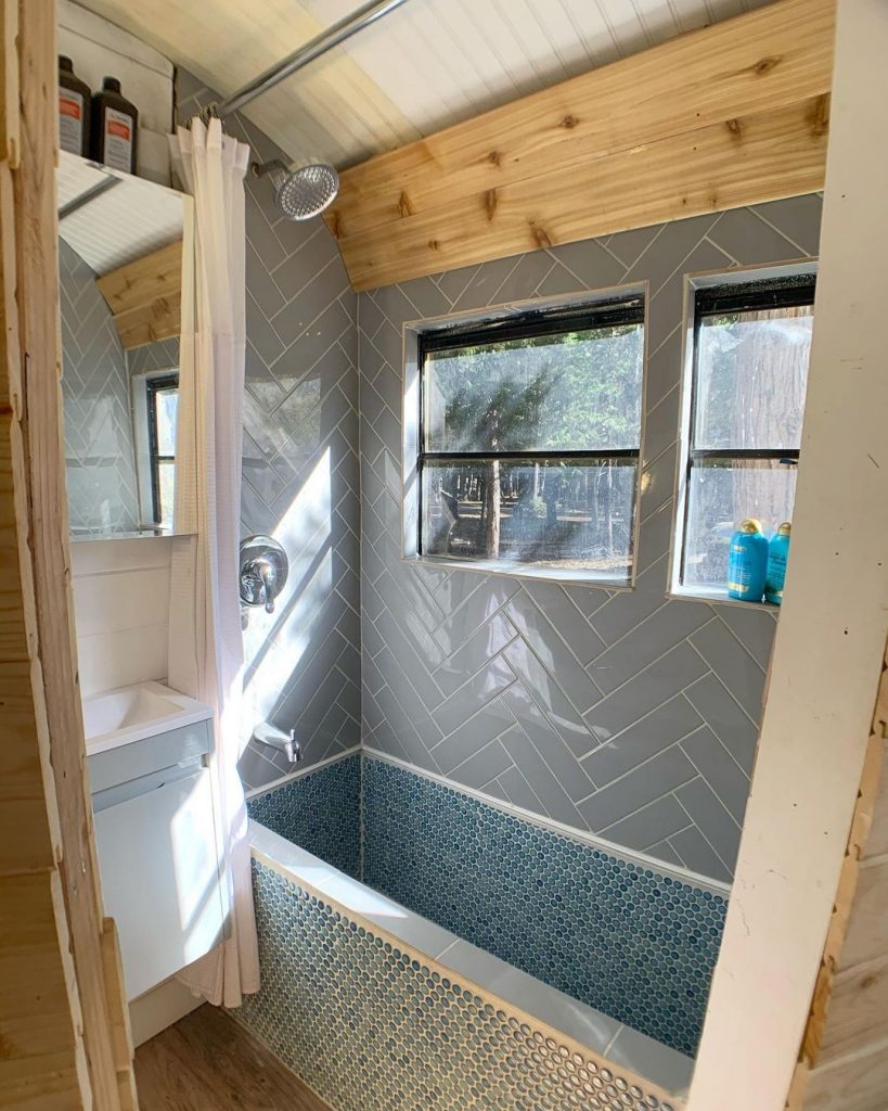 Skoolie bathroom with a full tiled bath tub. 