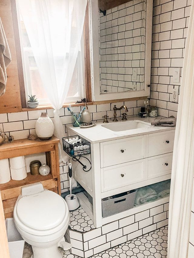 Beautiful white tiled skoolie bathroom from Kastle on Wheels