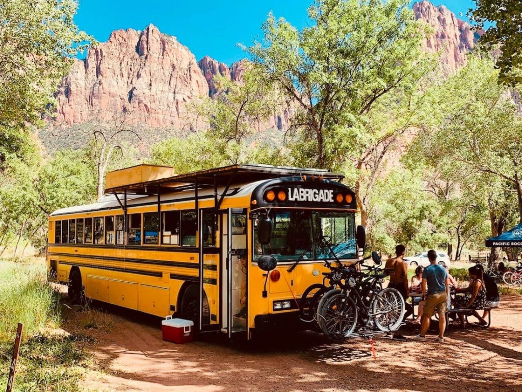 Skoolie shown from the outside, in a national park. 